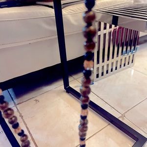 A long necklace made with wood and beads .